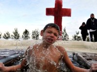 Em vídeo polêmico, criança é batizada por imersão em lago semicongelado na Sibéria e causa revolta. Assista