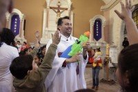 Padre usa batinas de super-heróis e pistola de brinquedo para jogar água benta em crianças durante missa