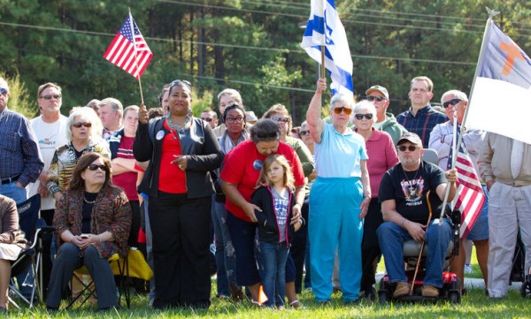 Manifestantes acompanham discursos com bandeiras de EUA e Israel e símbolos cristãos
