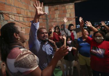 Pastor oferece consolo a pessoas durante o velório de vítimas da Covid-19