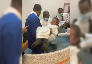 Dependente físico, homem recebe ajuda de fiéis para se batizar nas águas